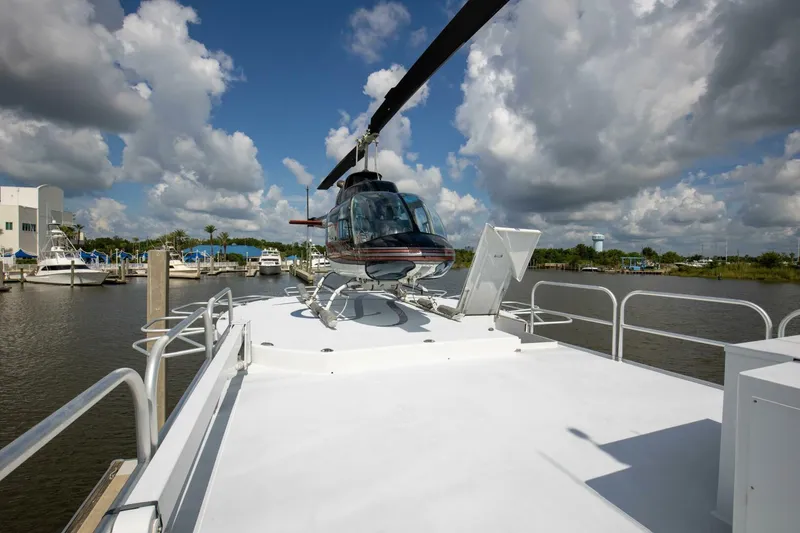 Slide: The Image of Helicopter on deck of 1983 Broward 108 Cockpit Motor Yacht in marina. - 37