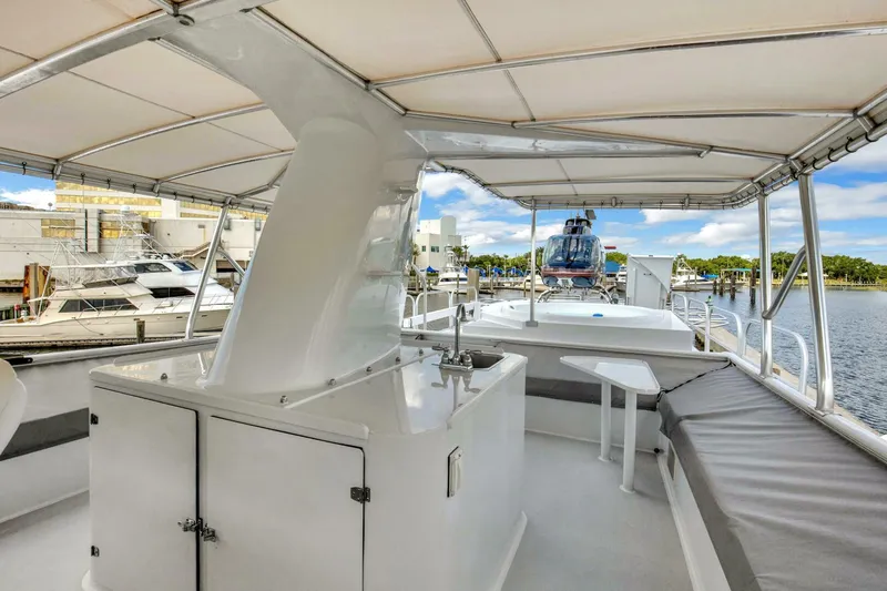 Slide: The Image of 1983 Broward 108 Cockpit Motor Yacht deck with seating and marina view. - 42
