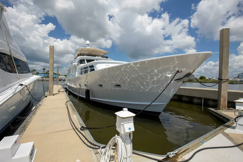 Slide: The Image of 1983 Broward 108 Cockpit Motor Yacht docked at marina under cloudy sky. - 49