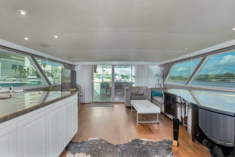 Slide: The Image of Luxurious interior of 1983 Broward 108 Cockpit Motor Yacht with modern furnishings and panoramic windows. - 8