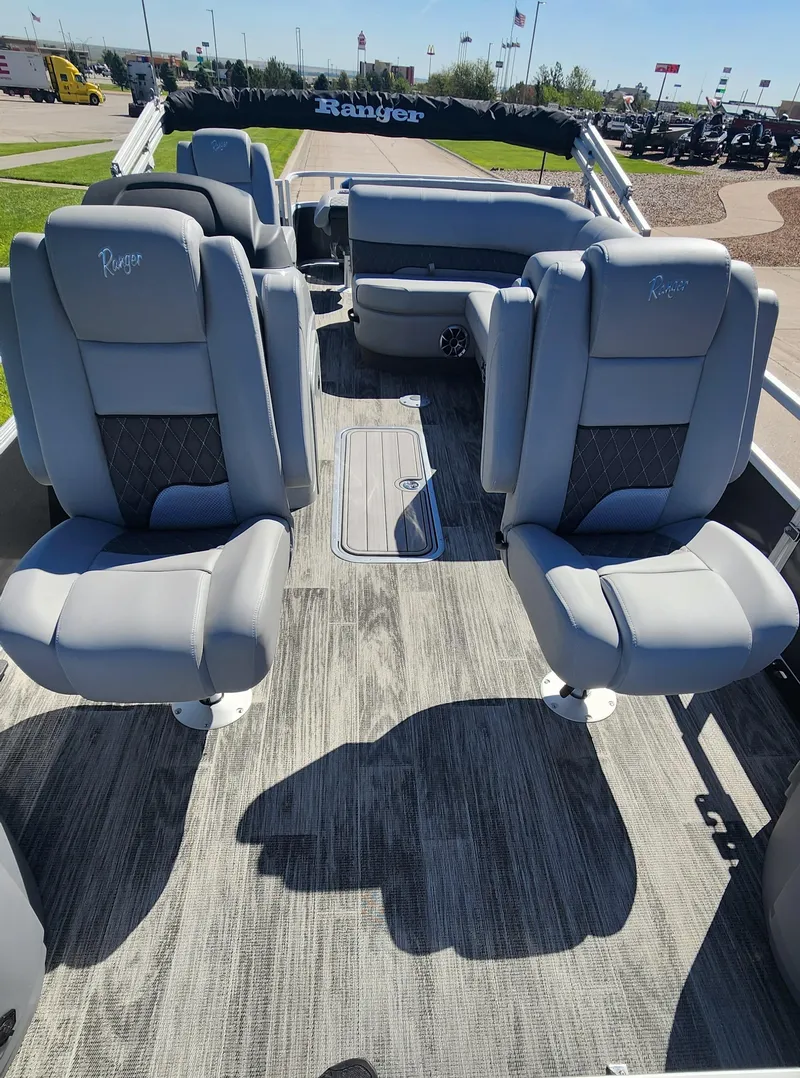 Slide: The Image of 2024 Ranger Reata 223F boat interior with gray seating and carpeted flooring. - 2