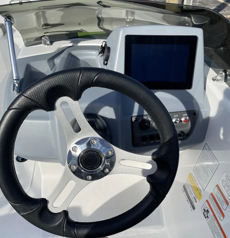 Slide: The Image of Steering wheel and dashboard of a 2024 Tahoe T16 boat. - 2