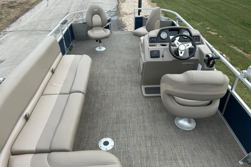 Slide: The Image of 2024 Ranger Reata 200F pontoon boat interior with beige seating and steering console. - 3