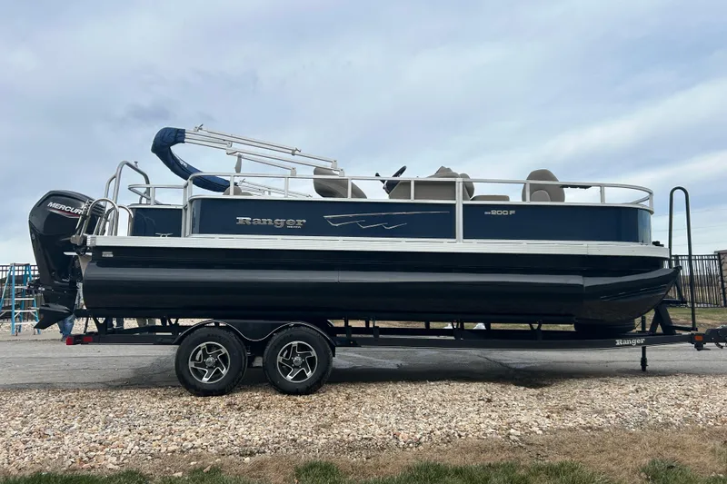 Slide: The Image of 2024 Ranger Reata 200F pontoon boat interior with beige seating and steering console. - 5