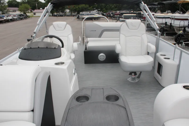 Slide: The Image of 2023 Lowe SS210 Super Sport pontoon boat interior with white seating and helm. - 11