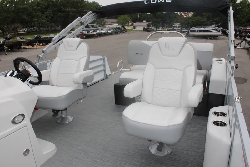 Slide: The Image of 2023 Lowe SS210 Super Sport pontoon boat with white seating and steering console. - 12