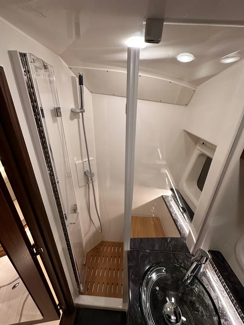 Slide: The Image of 2023 Sea Ray Sundancer 370 OB bathroom with modern shower and sleek sink design. - 25