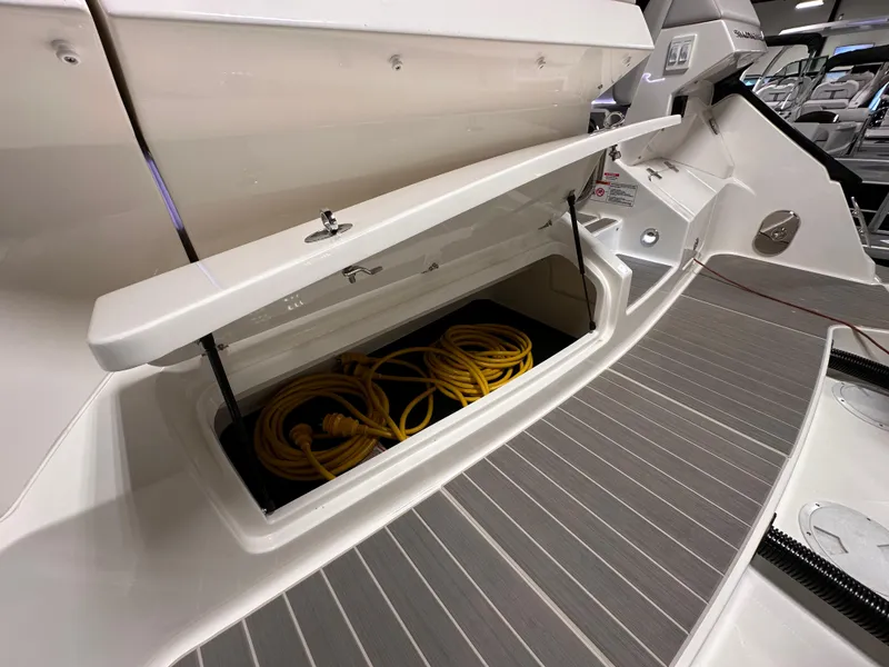 Slide: The Image of 2023 Sea Ray Sundancer 370 OB storage compartment with coiled yellow rope. - 35