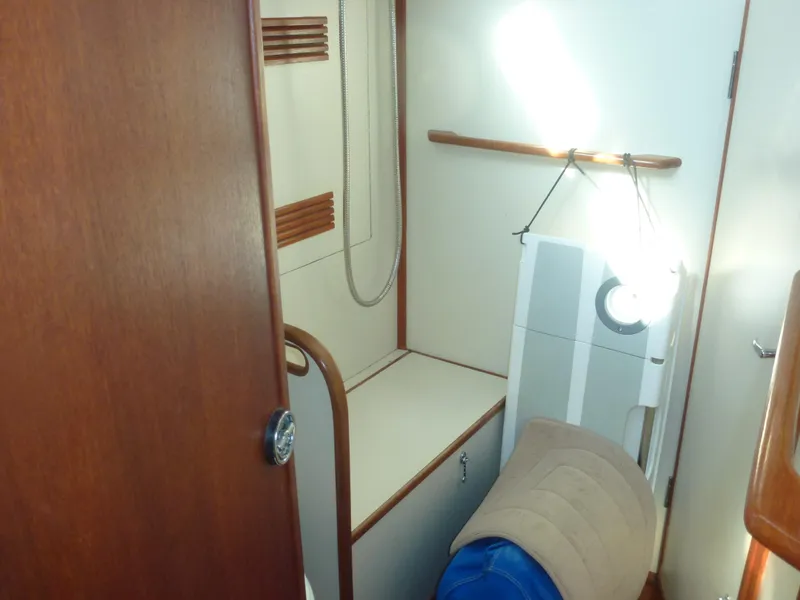 Slide: The Image of 1990 Sabre 425 boat interior with wooden accents and storage space. - 42