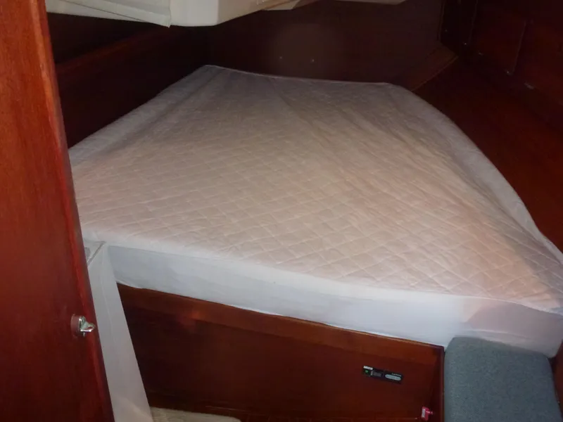 Slide: The Image of 1990 Sabre 425 boat cabin with a neatly made bed. - 48