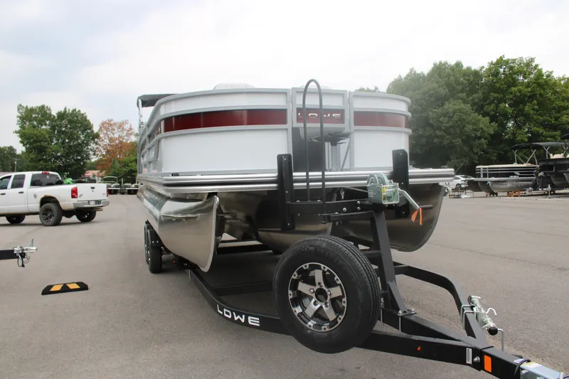 Slide: The Image of 2023 Lowe SF232 Sport Fish pontoon boat on trailer in parking lot. - 9