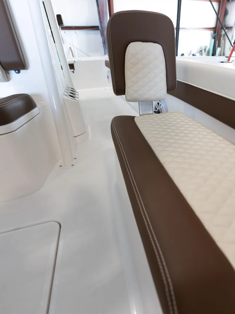 Slide: The Image of 2024 Caymas 28 Hybrid boat interior with brown and white quilted seating. - 23