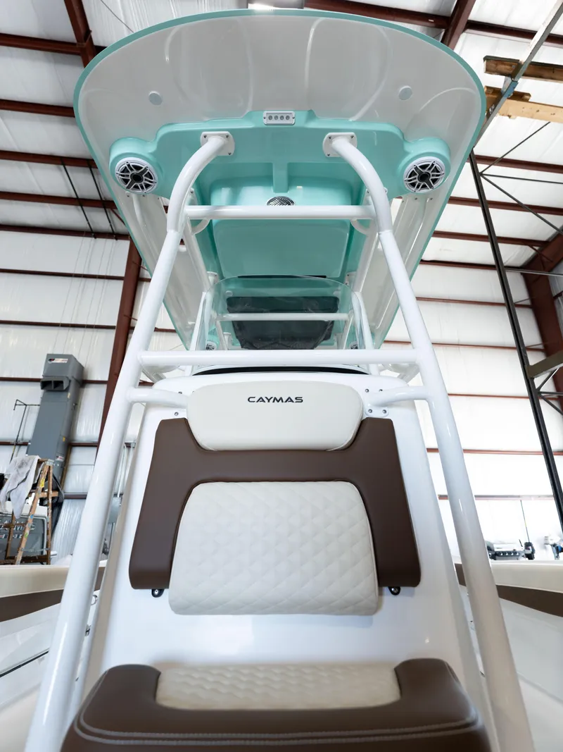 Slide: The Image of 2024 Caymas 28 Hybrid boat interior with cushioned seating and overhead speakers. - 24