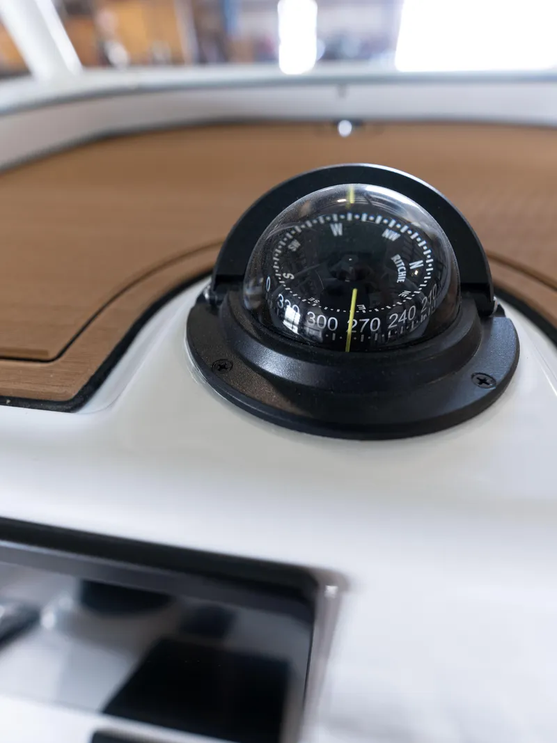 Slide: The Image of Compass on the dashboard of a 2024 Caymas 28 Hybrid boat. - 32