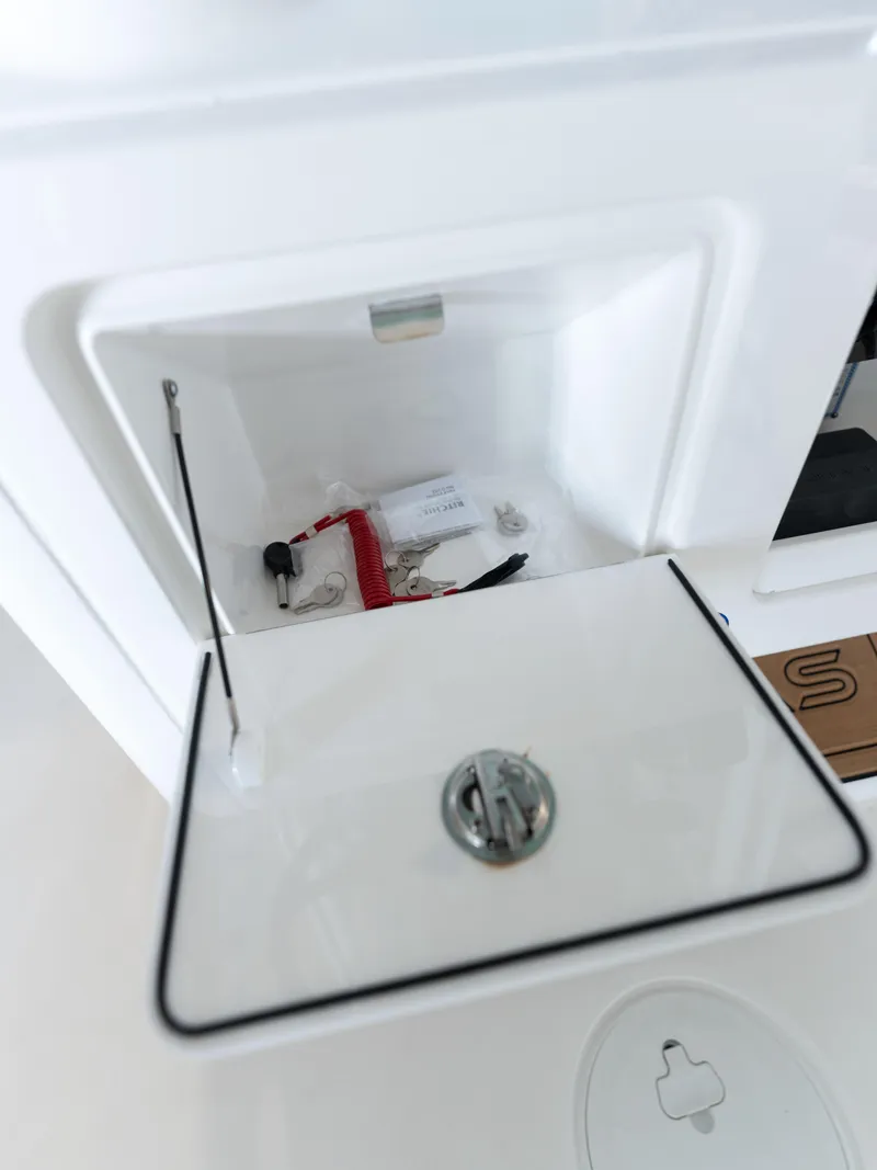 Slide: The Image of 2024 Caymas 28 Hybrid storage compartment with keys and accessories. - 39