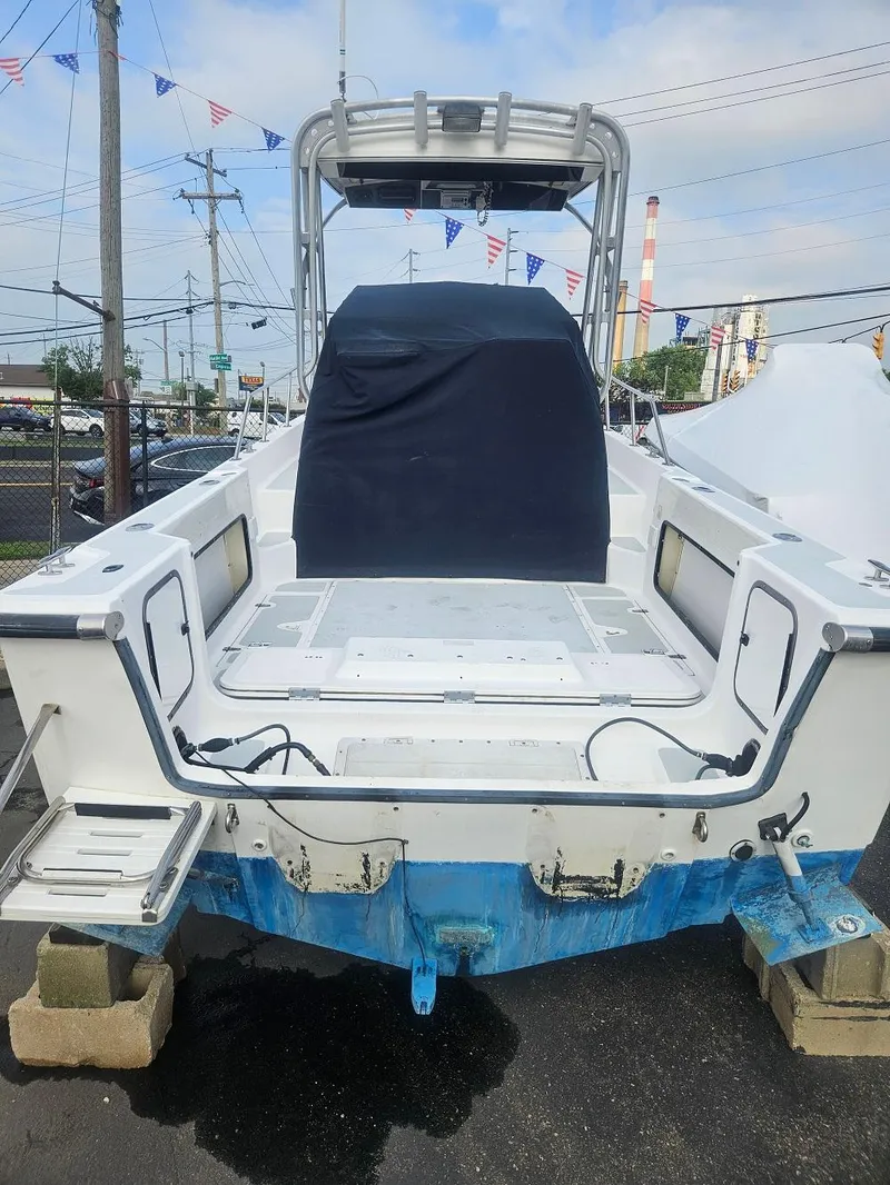 Slide: The Image of 1992 Boston Whaler 23 Walkaround boat on blocks, rear view with covered console. - 2