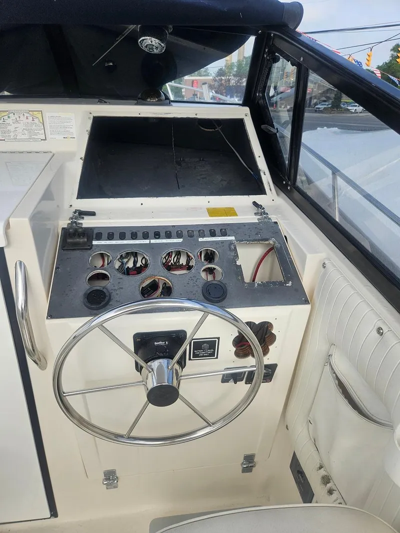 Slide: The Image of 1992 Boston Whaler 23 Walkaround boat dashboard with steering wheel and control panel. - 5