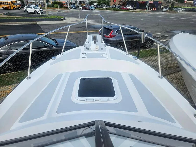 Slide: The Image of 1992 Boston Whaler 23 Walkaround boat deck view, parked near a busy street. - 6