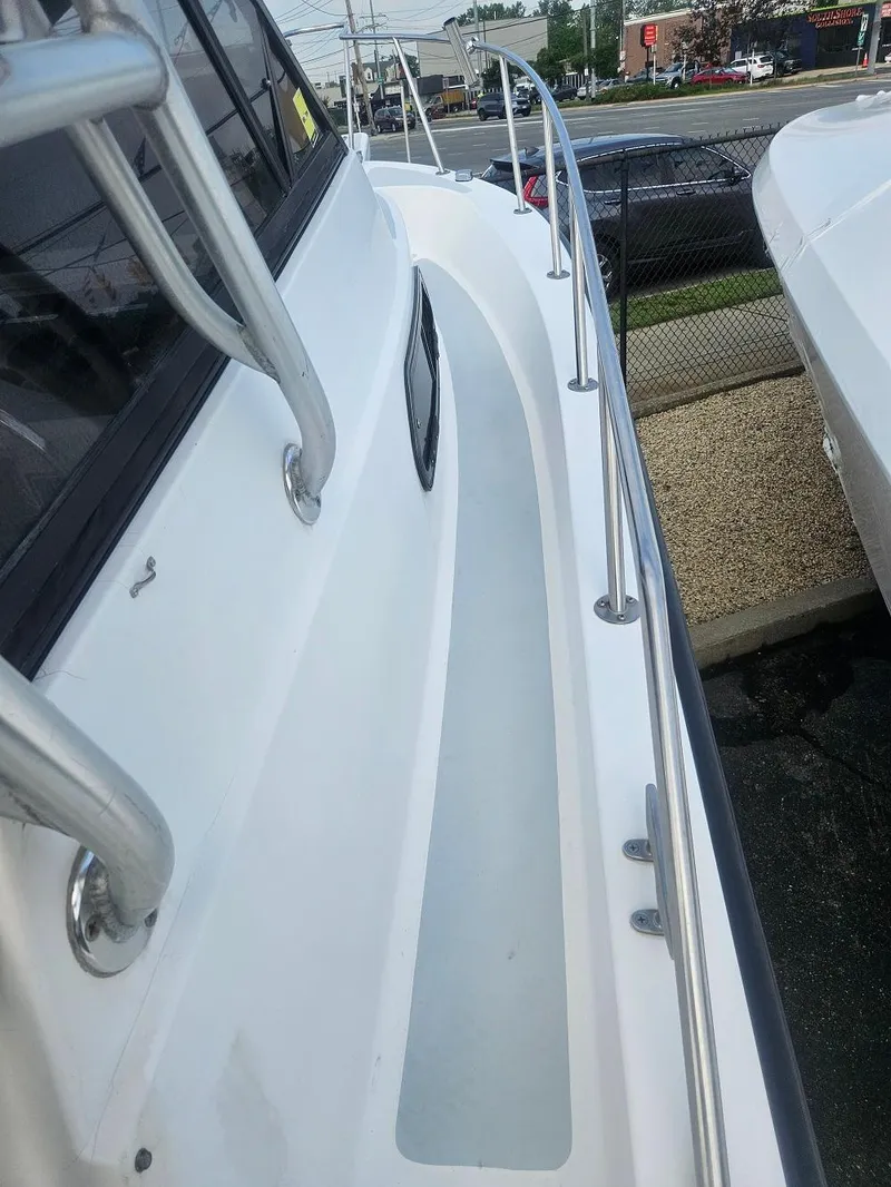 Slide: The Image of 1992 Boston Whaler 23 Walkaround boat deck with railing, parked outdoors. - 8