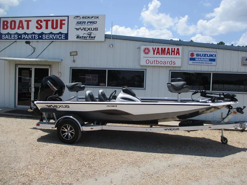 Slide: The Image of 2023 Vexus AVX181 boat on trailer outside dealership with Yamaha and Suzuki signage. - 0
