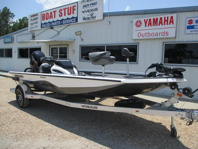 Slide: The Image of 2023 Vexus AVX181 boat on trailer at dealership, Boat Stuf, with Yamaha outboards signage. - 1