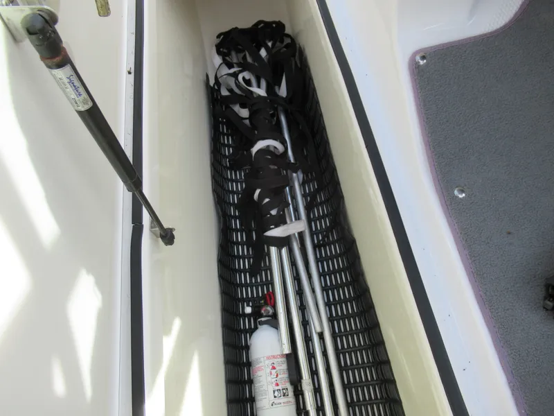 Slide: The Image of Storage compartment of a 2013 Yamaha Boats AR190 with fire extinguisher and equipment. - 17