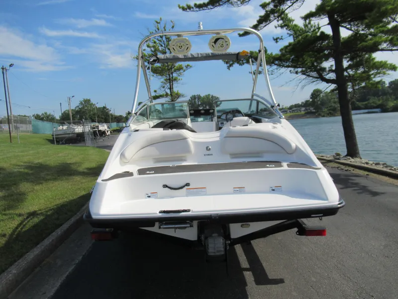 Slide: The Image of 2013 Yamaha Boats AR190, rear view, docked by a lake. - 4