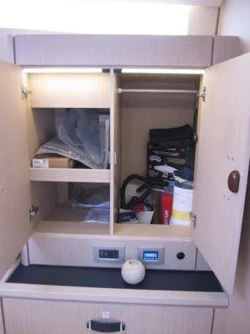 Slide: The Image of 2024 Jeanneau 55 yacht interior storage cabinet with shelves and electrical panel. - 46