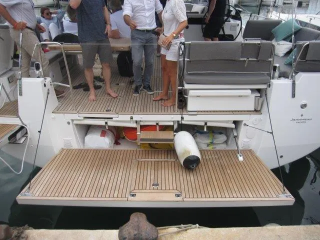 Slide: The Image of Jeanneau 55 yacht 2024 model with open storage compartments and people on deck. - 8