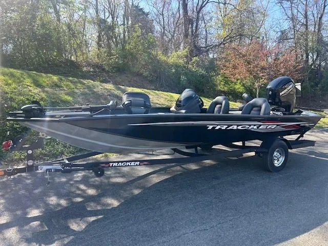 Slide: The Image of 2024 Tracker Pro Team 190 TX boat on trailer, parked on a sunny road. - 2
