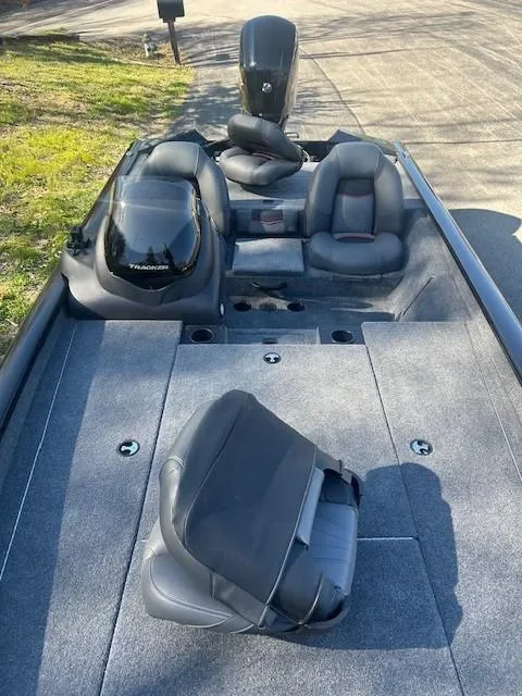 Slide: The Image of 2024 Tracker Pro Team 190 TX boat with seating and motor, parked on a sunny day. - 7