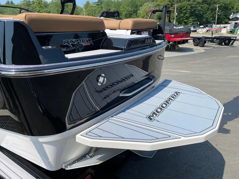 Slide: The Image of 2023 Moomba Craz boat rear view with swim platform and Raptor engine. - 2