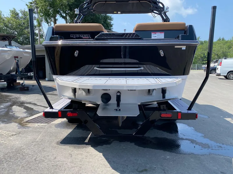 Slide: The Image of 2023 Moomba Craz boat rear view on trailer, black and white color scheme. - 3
