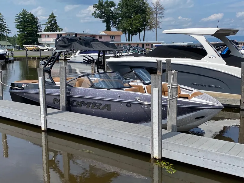 Slide: The Image of 2023 Moomba Craz boat docked at a marina on a sunny day. - 6