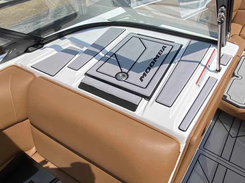 Slide: The Image of 2023 Moomba Craz boat interior with tan seats and gray deck padding. - 7