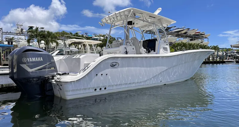 Slide: The Image of 2020 Sea Fox 328 Commander boat docked with Yamaha V8 engine, under clear blue sky. - 2