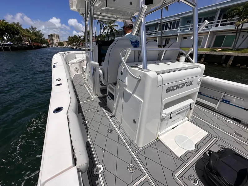 Slide: The Image of 2020 Sea Fox 328 Commander boat interior with seating and storage, cruising on a sunny day. - 7