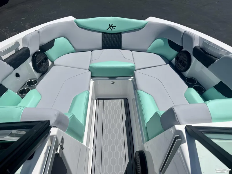 Slide: The Image of 2023 MasterCraft XT24 boat interior with mint and gray seating, cup holders, and speakers. - 4