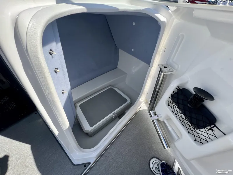 Slide: The Image of 2021 Yamaha AR250 boat interior storage compartment with cushioned seating and netted storage. - 6