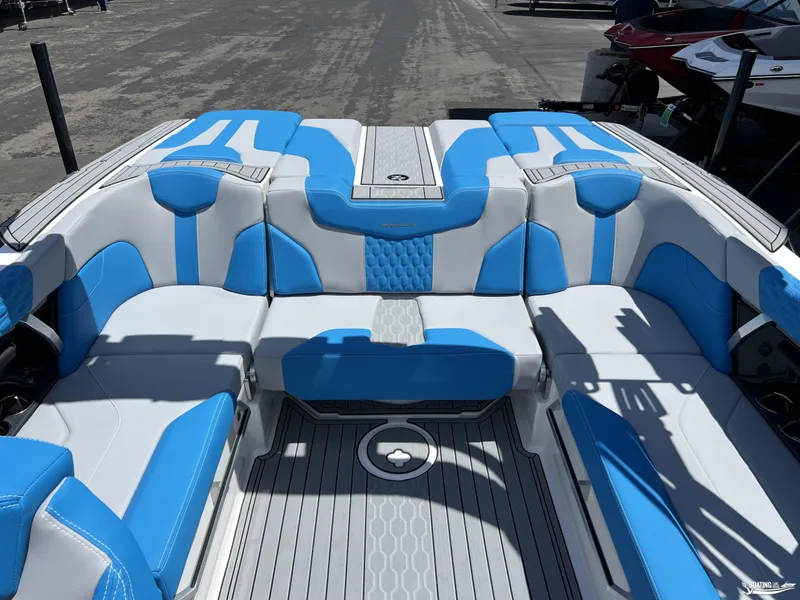 Slide: The Image of 2023 MasterCraft XT22 boat interior with blue and white seating, docked outdoors. - 7