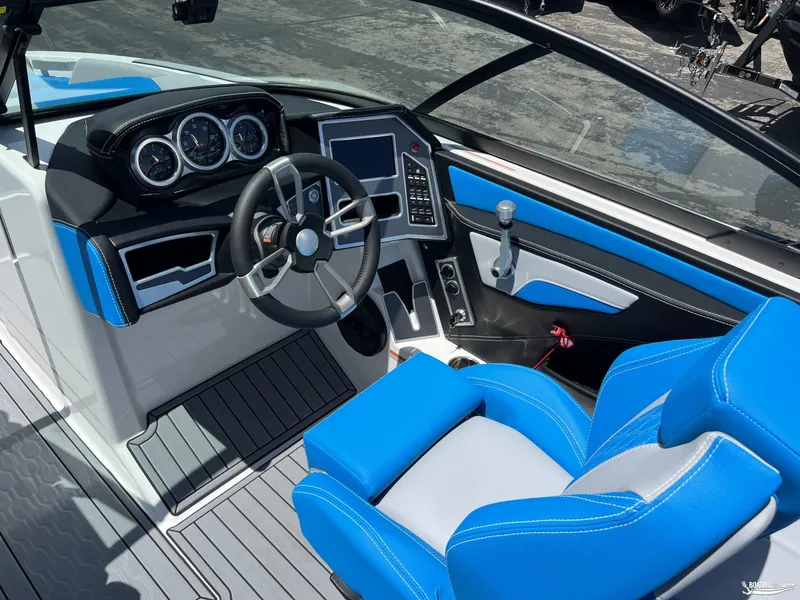 Slide: The Image of 2023 MasterCraft XT22 boat interior with blue and white seating, modern dashboard, and steering wheel. - 8