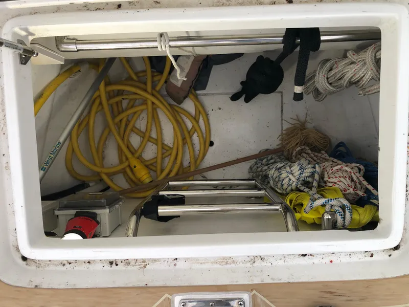 Slide: The Image of Storage compartment of 2020 Outbound 56 boat with ropes, ladder, and yellow hose. - 33