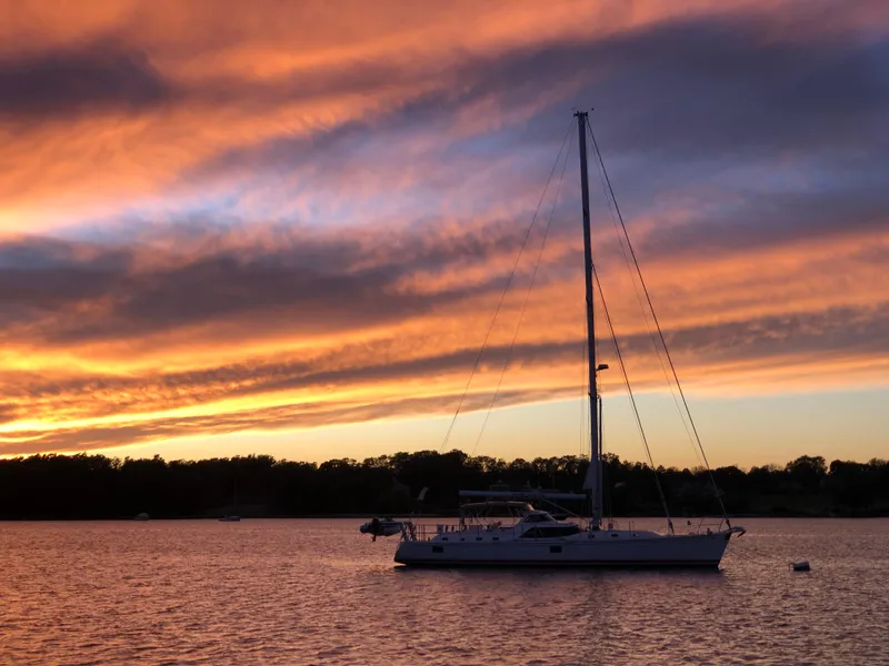 Slide: The Image of Sailboat Outbound 56 at sunset on calm water, 2020. - 44