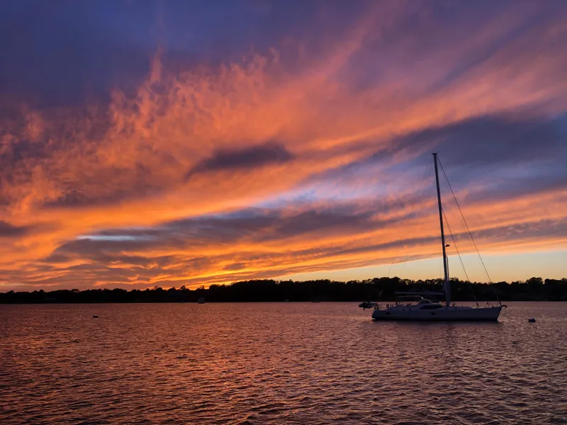 Slide: The Image of Sailboat on tranquil water at sunset, vibrant sky, Outbound 56, 2020 model. - 45