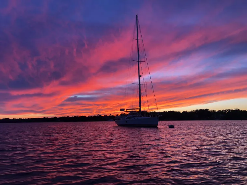 Slide: The Image of Sailboat on water at sunset with vibrant pink and purple sky, Outbound 56, 2020 model. - 46