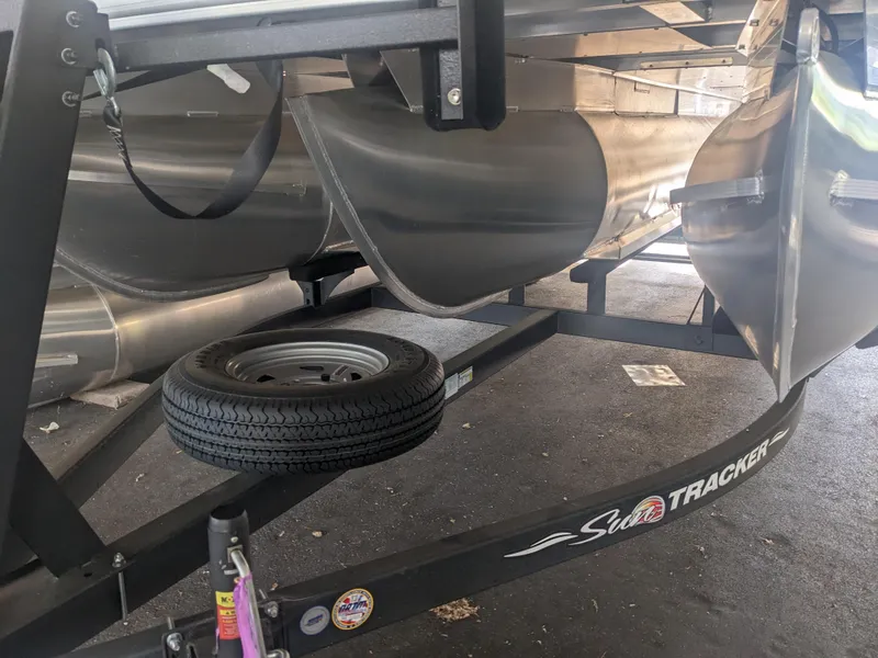 Slide: The Image of 2024 Sun Tracker Fishin' Barge 22 XP3 pontoon boat on trailer, close-up view. - 7