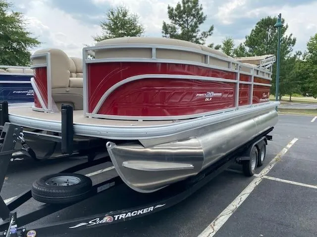 Slide: The Image of 2024 Sun Tracker Party Barge 20 DLX pontoon boat on trailer in parking lot. - 3