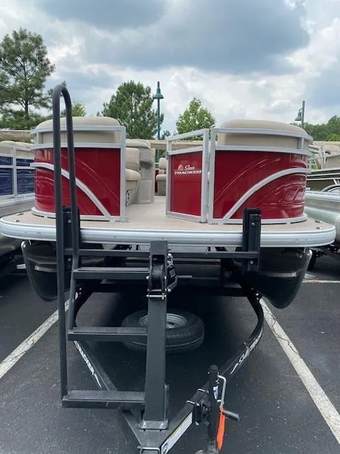 Slide: The Image of 2024 Sun Tracker Party Barge 20 DLX pontoon boat on a trailer, front view. - 6
