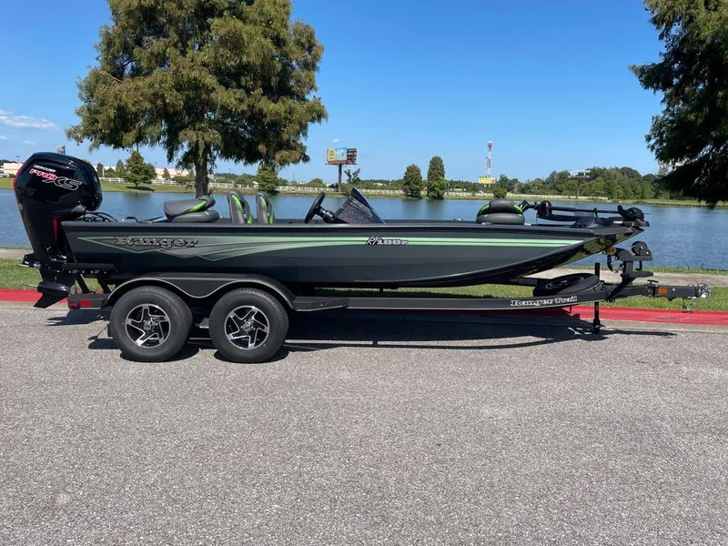 Slide: The Image of 2024 Ranger RT188P fishing boat on a trailer by a lake. - 0