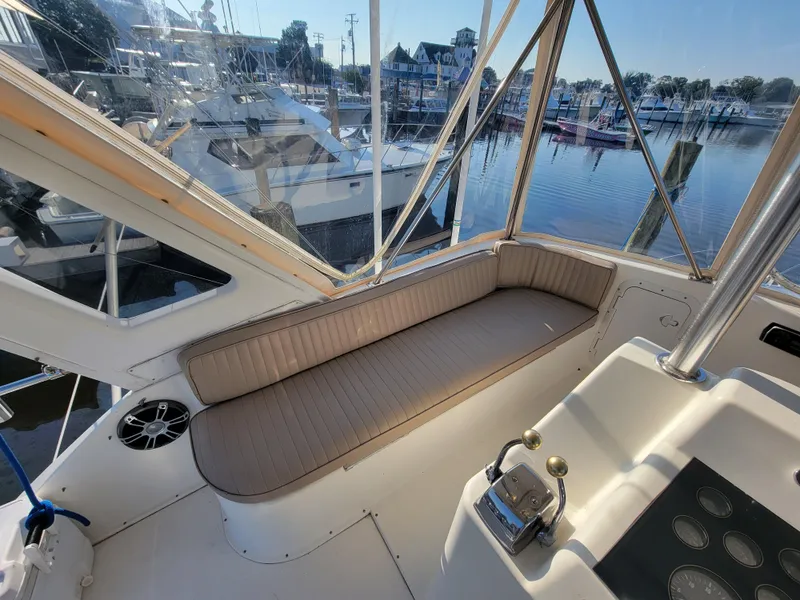 Slide: The Image of 1991 Ocean Yachts 42 Super Sport interior view with seating and marina background. - 22